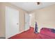 Cozy bedroom featuring red carpet, neutral walls, and an open doorway at 3121 Cruse Rd, Lawrenceville, GA 30044