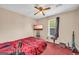 Cozy bedroom with red bedding, ceiling fan, and natural light at 3121 Cruse Rd, Lawrenceville, GA 30044