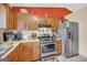 Traditional kitchen features wood cabinets, stainless steel appliances, and bright red accent wall at 3121 Cruse Rd, Lawrenceville, GA 30044