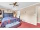 This spacious main bedroom features neutral walls, red carpet, and a ceiling fan at 3121 Cruse Rd, Lawrenceville, GA 30044