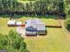 Aerial view of the home surrounded by a lush green lawn and tall trees at 303 Mill Glen Ct, Mcdonough, GA 30252