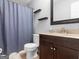 Bathroom with dark wood vanity and shower with blue curtain at 303 Mill Glen Ct, Mcdonough, GA 30252