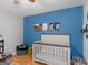 Bright bedroom with a white crib and blue accent wall at 303 Mill Glen Ct, Mcdonough, GA 30252
