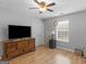 Bedroom with wood floors, ceiling fan, large dresser, and plenty of natural light at 303 Mill Glen Ct, Mcdonough, GA 30252