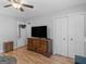 Bedroom featuring a dresser, ceiling fan, closet, and light wood floors at 303 Mill Glen Ct, Mcdonough, GA 30252