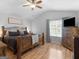 The main bedroom has light wood flooring and a large bed frame with an oversized headboard at 303 Mill Glen Ct, Mcdonough, GA 30252