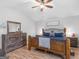 The main bedroom has light wood flooring, a vaulted ceiling, and is furnished with a large bed at 303 Mill Glen Ct, Mcdonough, GA 30252