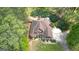 An aerial view of a two-story home with a brown roof and landscaped front yard surrounded by lush greenery at 4360 Derrick Rd, South Fulton, GA 30349