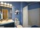 Cozy bathroom with blue walls, a shower with a white curtain, and a decorative mirror at 4360 Derrick Rd, South Fulton, GA 30349