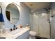 Well-lit bathroom with a modern vanity, a round mirror, and a walk-in shower with glass doors at 4360 Derrick Rd, South Fulton, GA 30349