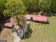 Expansive aerial view featuring a red-roofed home, detached shed, and a long driveway surrounded by lush greenery at 361 Cecil Hunter Rd, Moreland, GA 30259