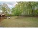 Spacious backyard view, featuring partial exterior of the home and surrounding trees at 361 Cecil Hunter Rd, Moreland, GA 30259