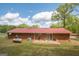 Back exterior view of the brick home with a metal roof and a patio at 361 Cecil Hunter Rd, Moreland, GA 30259