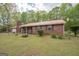 Front exterior view of a brick home with a metal roof and well-manicured landscaping at 361 Cecil Hunter Rd, Moreland, GA 30259