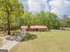 Charming single-story home featuring a red roof, brick chimney, and a spacious lawn with mature trees at 361 Cecil Hunter Rd, Moreland, GA 30259