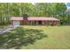 Exterior view of a brick home featuring a metal roof, driveway, and well-kept lawn at 361 Cecil Hunter Rd, Moreland, GA 30259