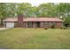 Exterior view of a brick home featuring a metal roof, a front porch, and a spacious yard at 361 Cecil Hunter Rd, Moreland, GA 30259