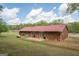 Back exterior view of the brick home featuring a metal roof and a small patio area at 361 Cecil Hunter Rd, Moreland, GA 30259