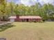 Charming ranch-style home with a red metal roof, brick chimney and an expansive green lawn at 361 Cecil Hunter Rd, Moreland, GA 30259