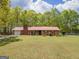 Charming ranch-style home with a red metal roof, brick chimney and an expansive green lawn at 361 Cecil Hunter Rd, Moreland, GA 30259