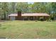 Traditional ranch with brick exterior, red metal roof, and attached garage at 361 Cecil Hunter Rd, Moreland, GA 30259