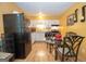 Bright kitchen with black refrigerator, white cabinets, and glass table with chairs at 361 Cecil Hunter Rd, Moreland, GA 30259