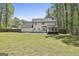 A long backyard with green grass, a sunroom, a brick patio, and a wood fence at 214 Windgate Ct, Peachtree City, GA 30269