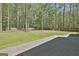 Spacious backyard with green grass, mature trees, a wood fence, and a brick patio at 214 Windgate Ct, Peachtree City, GA 30269
