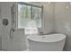 Bright bathroom featuring a modern soaking tub, shower, and large window for natural light at 214 Windgate Ct, Peachtree City, GA 30269