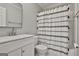 Neutral bathroom featuring a vanity, toilet, shower/tub combination, and a patterned shower curtain at 214 Windgate Ct, Peachtree City, GA 30269