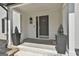 Inviting front entrance with a covered porch, elegant light fixture, and decorative planters at 214 Windgate Ct, Peachtree City, GA 30269