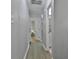 Hallway with light grey walls and wood-look flooring, leading to rooms with white doors at 214 Windgate Ct, Peachtree City, GA 30269