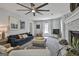 Spacious living room with a fireplace, large ceiling fan, and abundant natural light at 214 Windgate Ct, Peachtree City, GA 30269