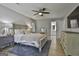 A nicely decorated main bedroom showcasing a ceiling fan, queen bed, dresser, and an ensuite bathroom at 214 Windgate Ct, Peachtree City, GA 30269