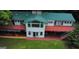 Aerial view showcases a home with a green metal roof, surrounding deck, and a well-maintained lawn at 2316 Emerald Dr, Jonesboro, GA 30236