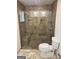 Well-lit bathroom featuring a glass enclosed shower, toilet, and refined tile work at 2316 Emerald Dr, Jonesboro, GA 30236
