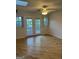 Light-filled room with wood floors, ceiling fan, and French doors leading to a backyard view at 2316 Emerald Dr, Jonesboro, GA 30236