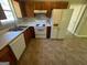 Kitchen featuring wood cabinets, white appliances, and tile flooring for easy maintenance at 194 Bay Court Dr, Stockbridge, GA 30281