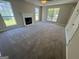 Living room with a fireplace, carpet, and abundant natural light through several windows at 194 Bay Court Dr, Stockbridge, GA 30281