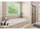 A bathroom with a soaking tub next to a window, and a shower with black trim at 229 Primstone Way, Mcdonough, GA 30253