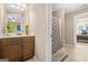 Well-lit bathroom featuring a vanity with dark wood cabinets and a shower with patterned curtain at 229 Primstone Way, Mcdonough, GA 30253