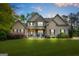 Charming two-story home featuring a manicured lawn, stone accents, and a welcoming front porch with blue rocking chairs at 229 Primstone Way, Mcdonough, GA 30253