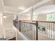 Spacious hallway with wood and iron railing overlooking the entry and beautiful arched doorways at 229 Primstone Way, Mcdonough, GA 30253