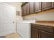 This laundry room features a washer and dryer, custom cabinets, and a neutral color scheme at 229 Primstone Way, Mcdonough, GA 30253