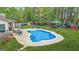 Aerial view of a backyard pool with a concrete deck, seating, and well-manicured lawn at 229 Primstone Way, Mcdonough, GA 30253