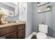 Stylish powder room with granite countertop, round mirror, and charming decorative accents at 229 Primstone Way, Mcdonough, GA 30253