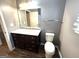 Bathroom with dark wood vanity, mirror, and toilet at 4254 Wood Cove Dr, Snellville, GA 30039