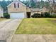 Two-story brick home featuring an attached two-car garage, well-maintained lawn and mature landscaping at 4254 Wood Cove Dr, Snellville, GA 30039