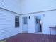 Back porch features white siding, a diamond latticed glass door, a window and dark red painted deck at 30 Hickory Dr, Stockbridge, GA 30281