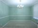 A large room featuring green walls, carpet, and a chandelier at 30 Hickory Dr, Stockbridge, GA 30281